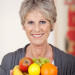 Smiling caregiver holding a variety of fruit