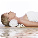 a caregiver lying flat with a roll under her neck awaiting a massage