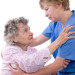 nurse helping a senior rise up from a chair