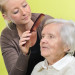 senior woman with her caregiver who is combing her hair