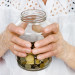 a senior woman holding a jar of coins